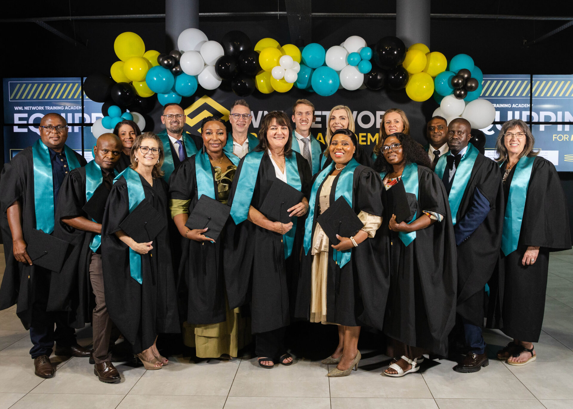 Graduates in teal stoles smiling together